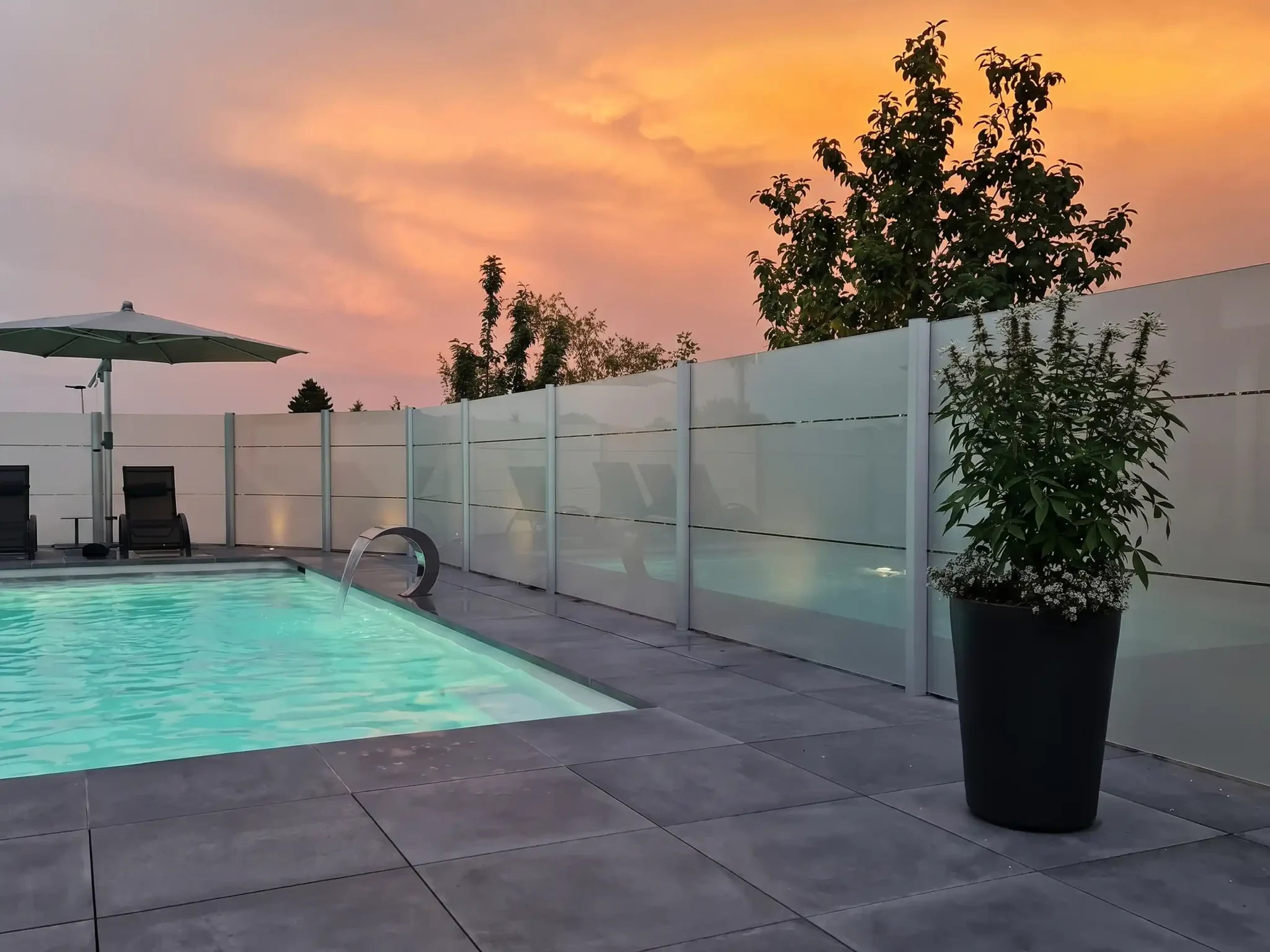 Poolbereich mit Beleuchtung und Sichtschutz am Abend